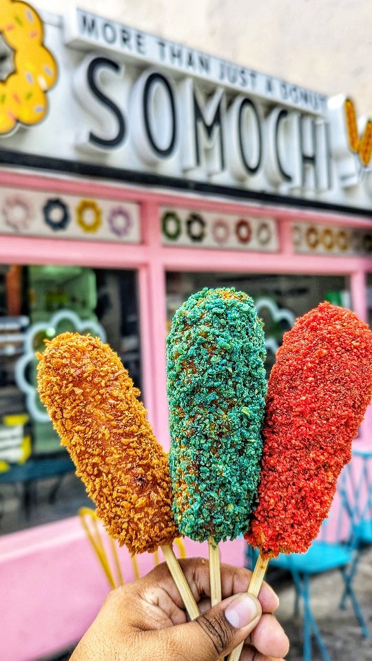 K rice corn dogs in front of pink storefront